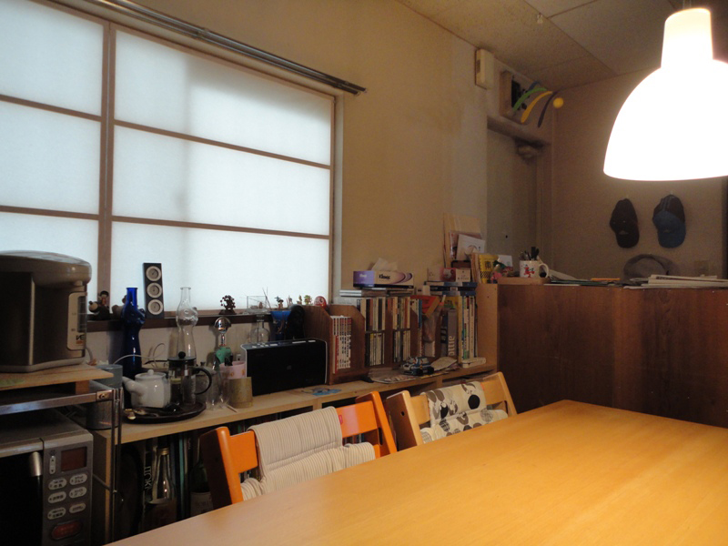 棚には様々な日用品が置かれます。2014年にテーブルを壁から離して、４方向から使えるレイアウトにしました。