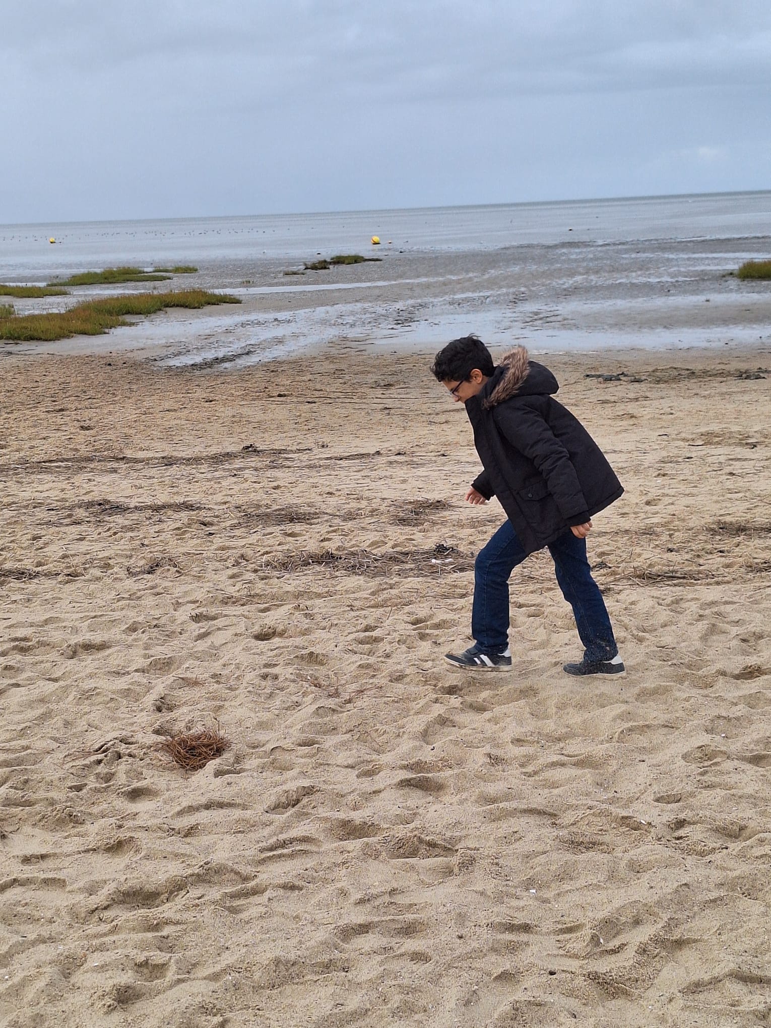 Ein Junge läuft über den Strand.