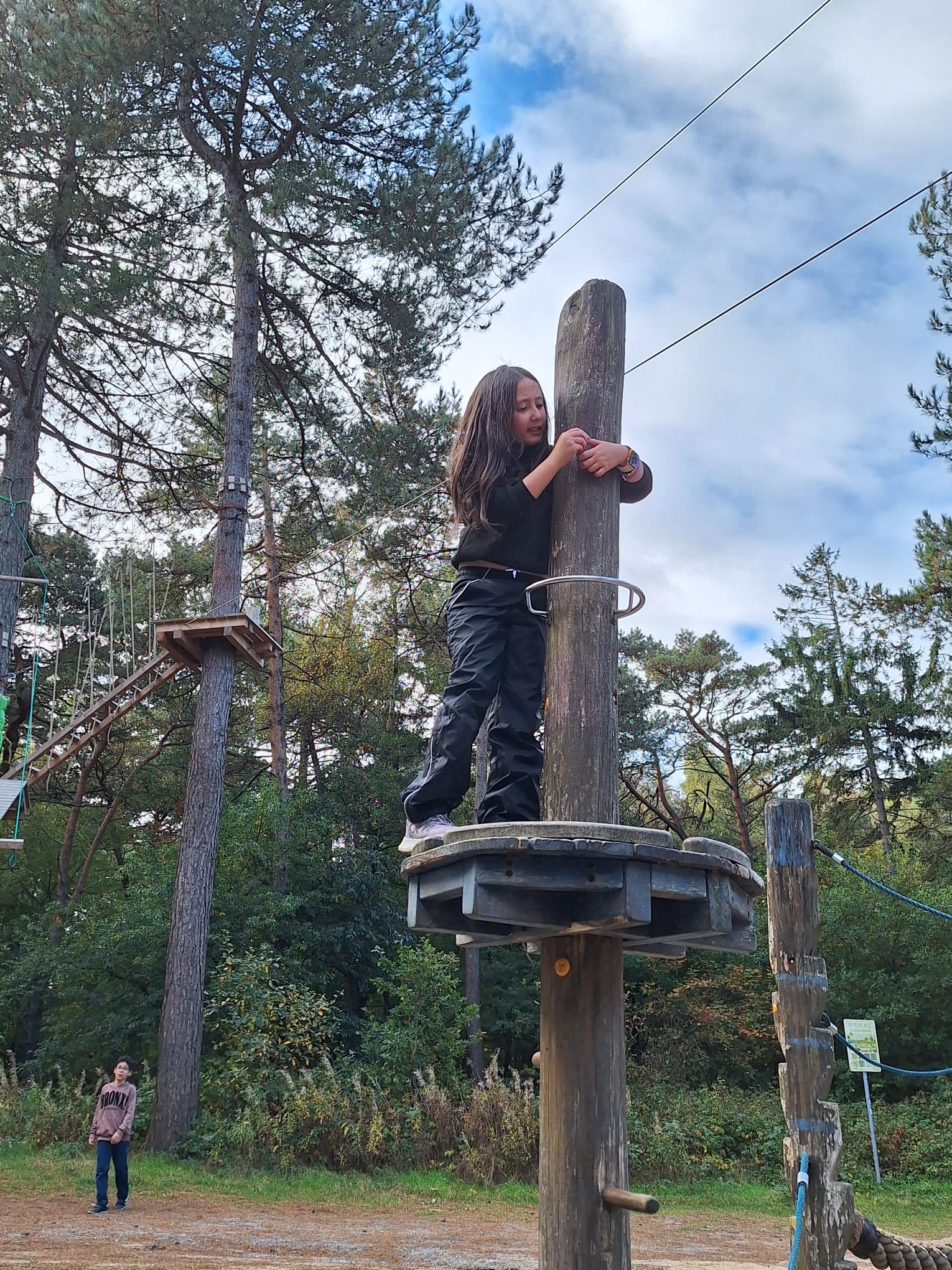 Ein Mädchen steht auf einer Holzplattform.