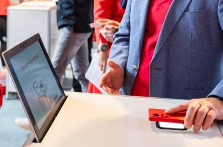 Hand hält Smartphone über Scanner