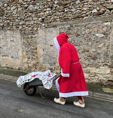 La neige étant absente, le Père Noël assure la distribution des colis de Noël avec une brouette.