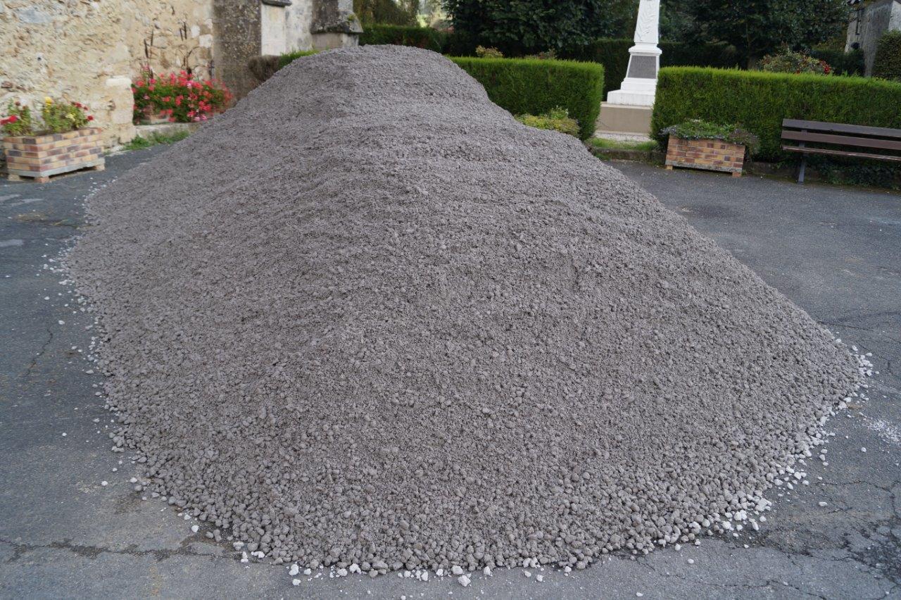 Après l'installation d'un film géotextile au fond de la tranchée, une assise d'une épaisseur de 30cm est réalisée en déposant une couche de grave non traitée (GNT), calibre 0/20..