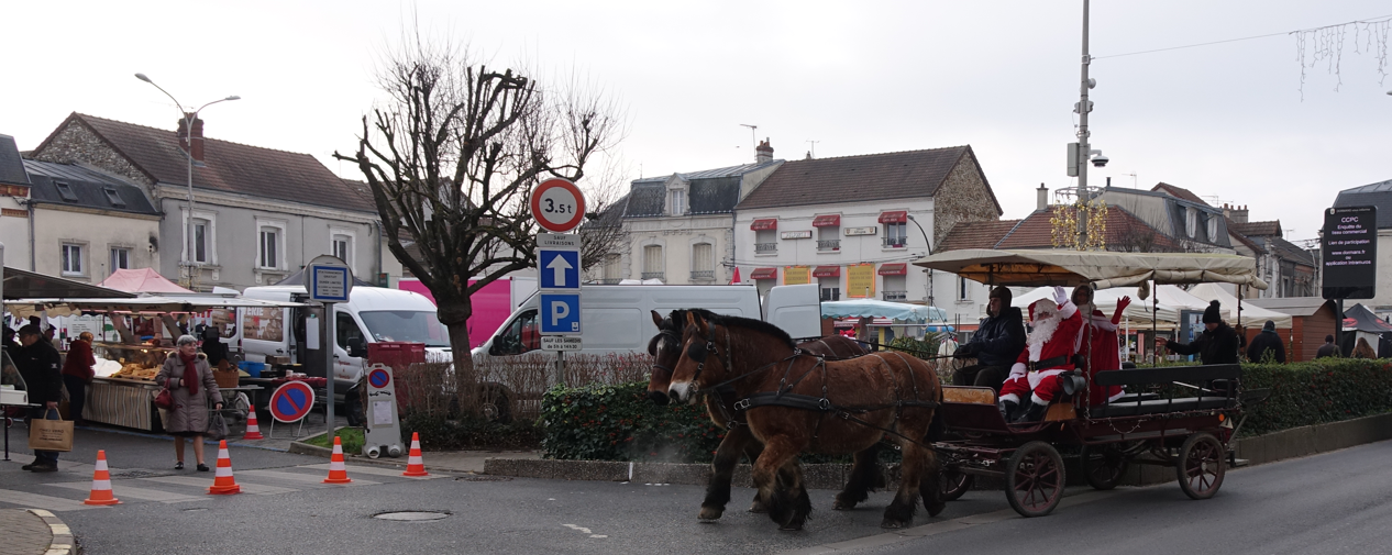 Juché sur le char à bancs tiré par de magnifiques chevaux aux ordres de Jérôme de Juriew, le Père Noël arrive sur le Marché....