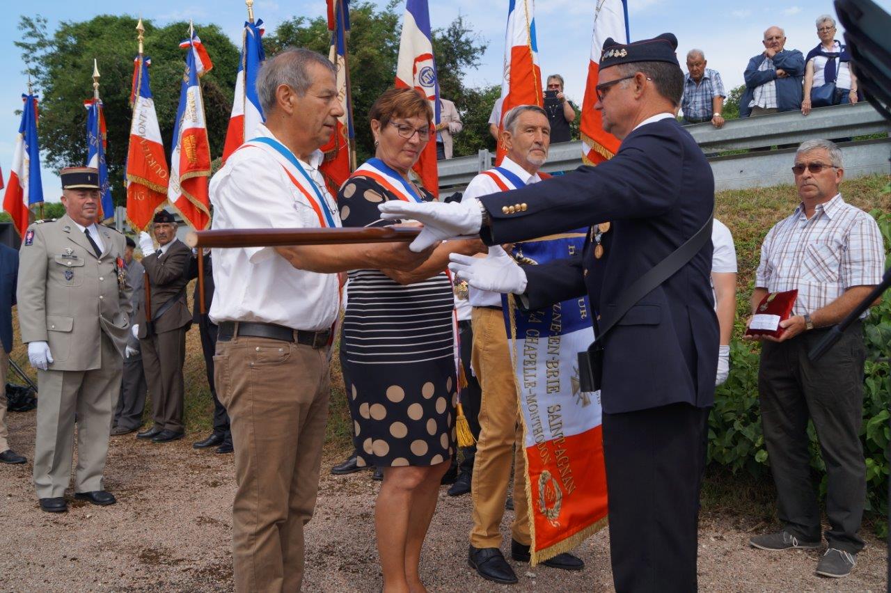 De gauche à droite : Bruno Lahouati, Jacqueline Picart et Pierre Troublé, adjoint au maire délégué de Saint-Agnan, remettent le drapeau de la commune Vallées-en-Champagne à Marcel Dartinet, porte-drapeau et ancien combattant...