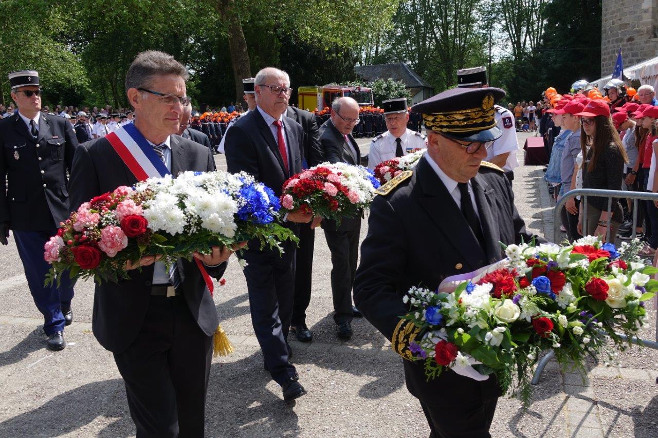 De gauche à droite : Michel Courteaux et Denis Conus déposent chacun une gerbe de fleurs en hommage aux sapeurs-pompiers morts en service.