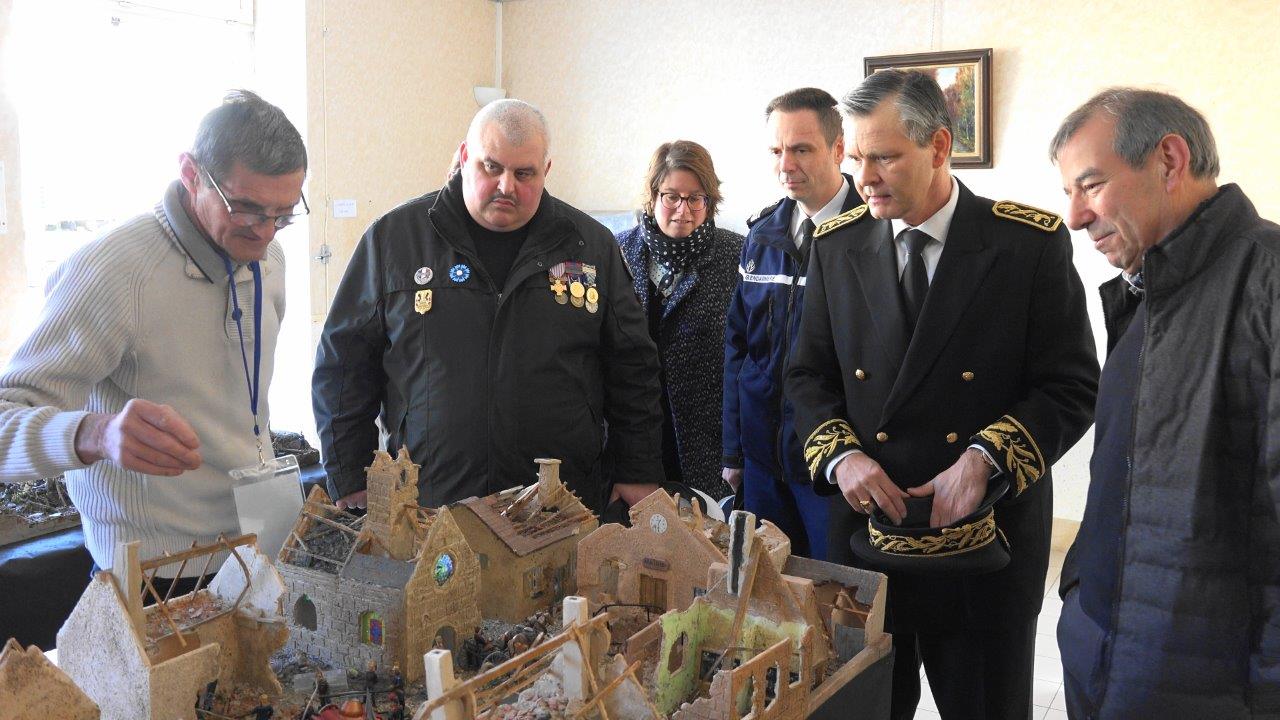 A gauche, Christian Leclère présente la maquette d'un village français détruit au cours de la Grande guerre.