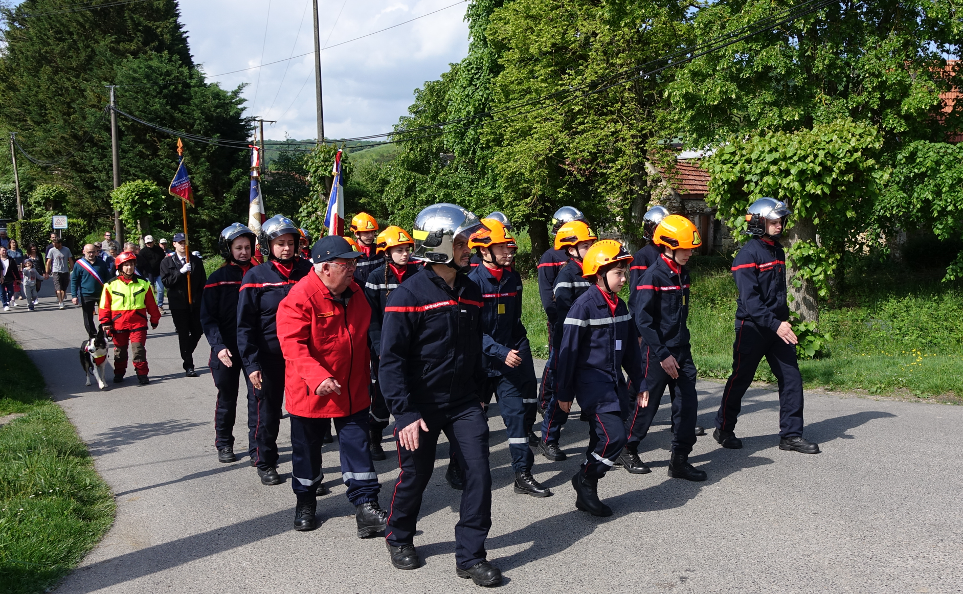 Après le rassemblement sur la place de l'église de Saint-Eugène, la délégation de sapeurs-pompiers et jeunes sapeurs-pompiers de la caserne conduit les participants au monument aux morts.