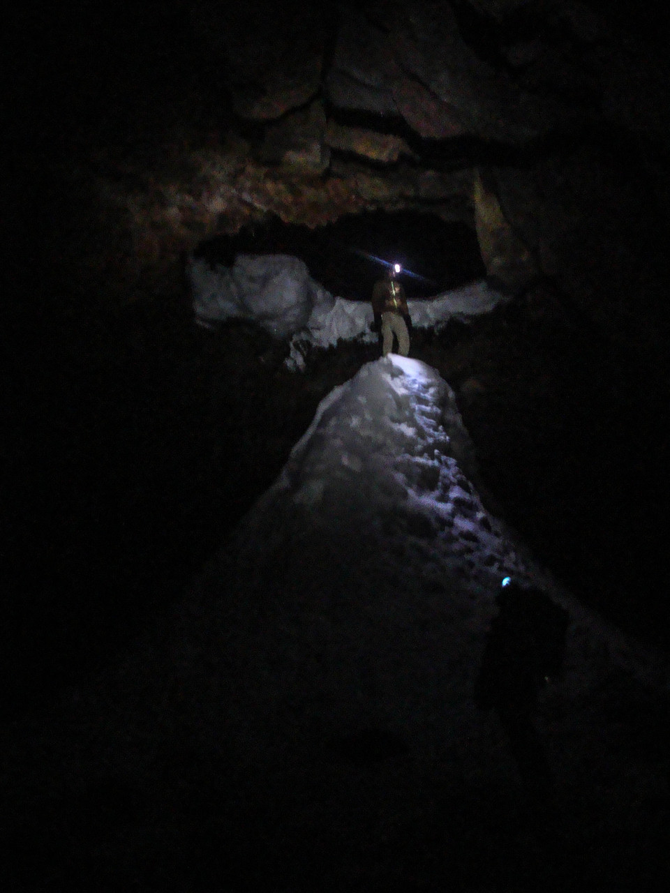 Climbing small snow hills, which are under holes of the lava cave roof.
