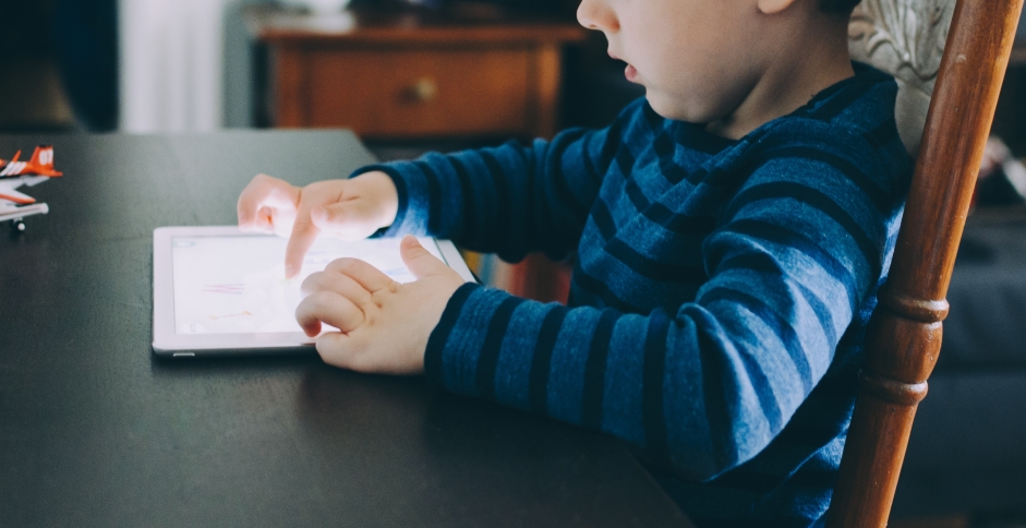 Un enfant utilisant une tablette tactile, donc soumis aux effractions digitales