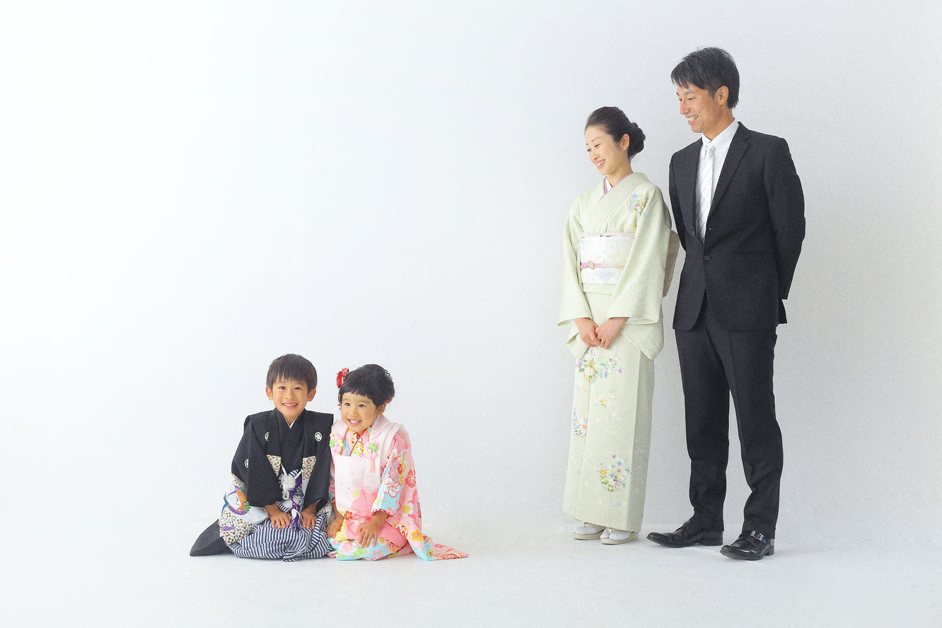 兄と妹が床に正座で隣にパパママが嬉しそうに見つめている素敵な写真