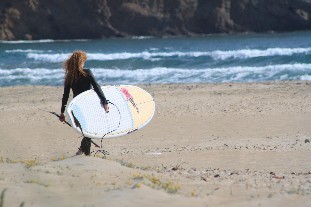 Stand Up Paddle Surferin mit Neoprenanzug