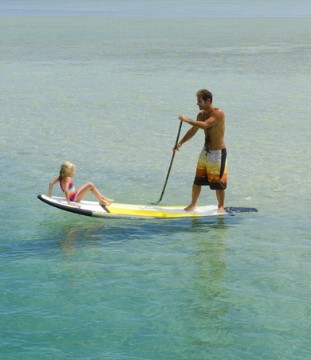 Stand Up Paddler mit Kind an Board