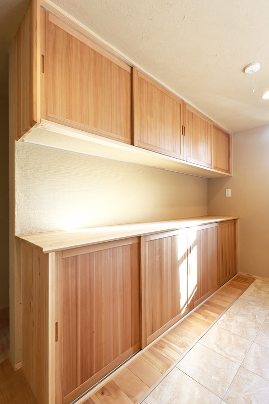 キッチンの背面には秋田杉 官木の赤柾目の建具を使用した作り付けの家具