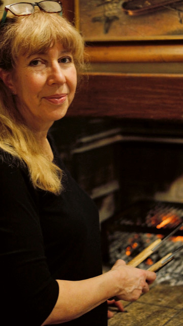 Esther Villiger legt in der Gaststube einen Braten über die Glut.