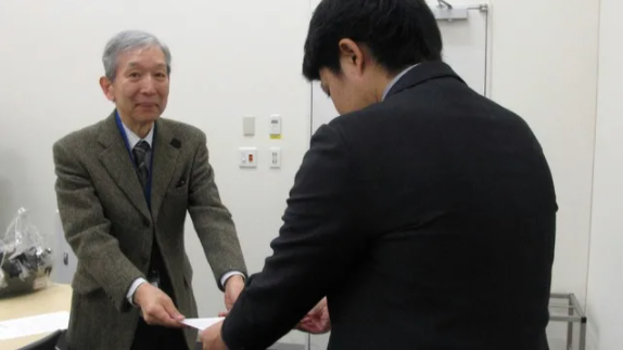 当会共同代表の赤澤史郎が防衛省担当者に陳情書を渡す