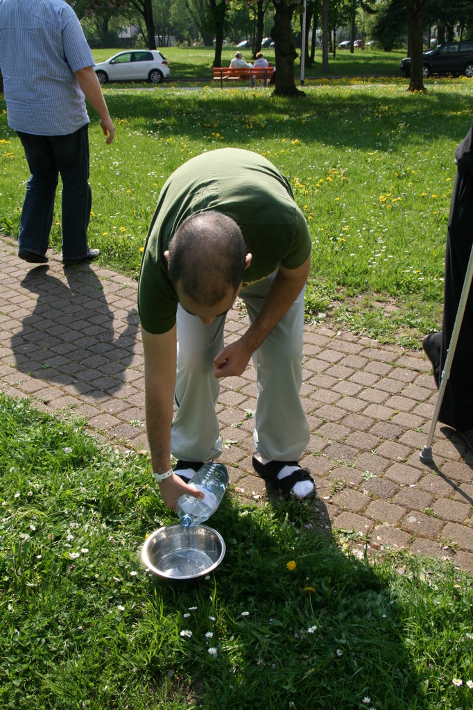 Nach unten beugen (Förderung der Grobmotorik, Vestibuläre Stimulation) und Wasser gezielt in Schüssel leeren (Feinmotorikübungen)                                n