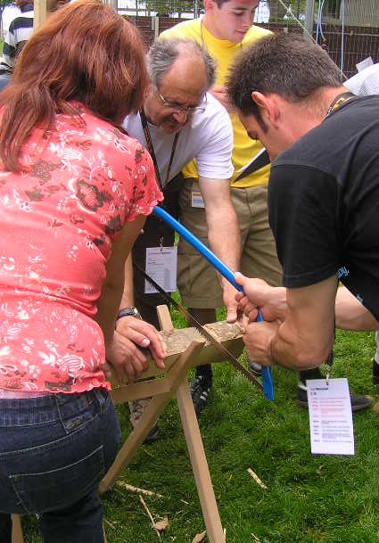 Baumstammsägen für die Bauernhofrallye ist eine Teamaufgabe für Ihren Teamevent oder Ihre Mitarbeiterveranstaltung