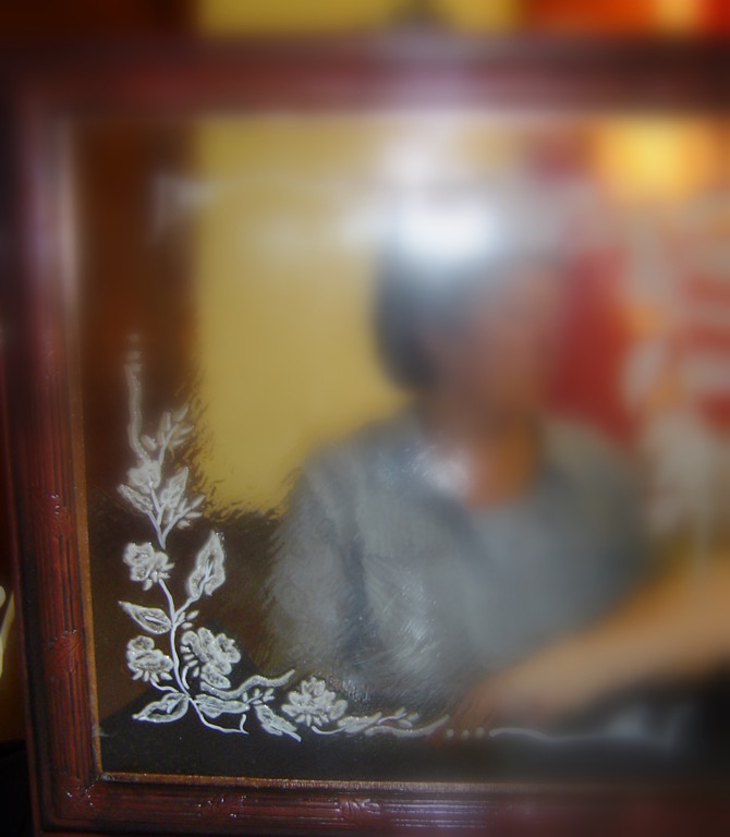 Sur la vitre un dessin de fleurs exécuté avec une pâte et enduit d'un scellant transparent.