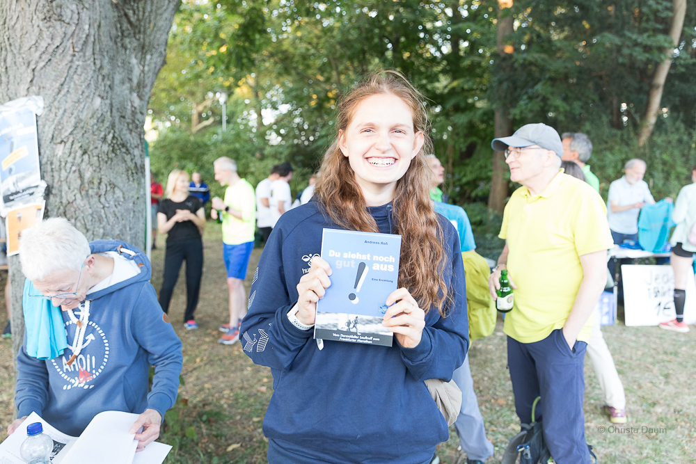 45. Hutzellauf 2024, Darmstädter Lauf-Treff, Clara Costadura (HLV) mit dem Buch "Du siehst noch gut aus" von Andreas Ross, Foto: Christa Daum