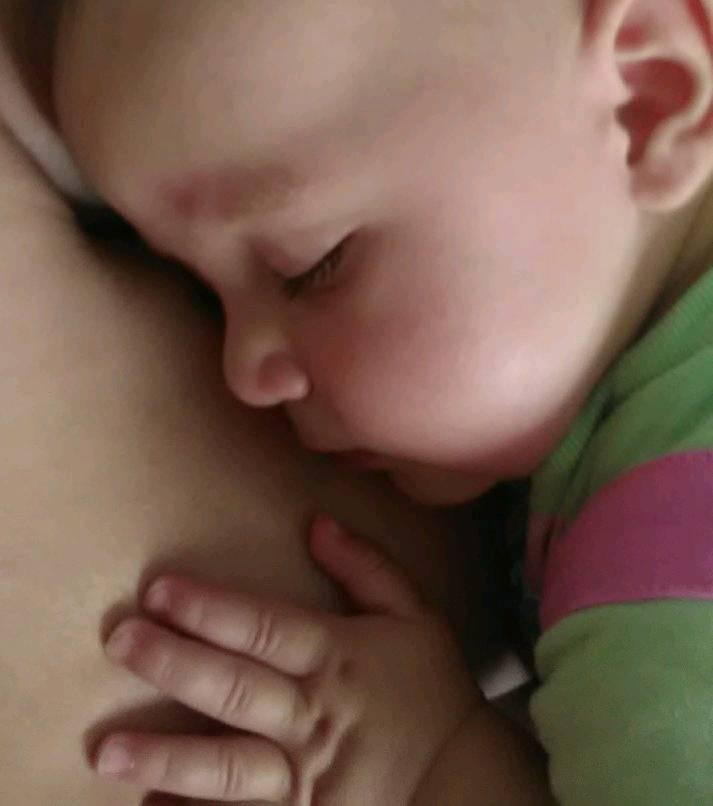 A happy baby, havng fallen asleep at the breast.