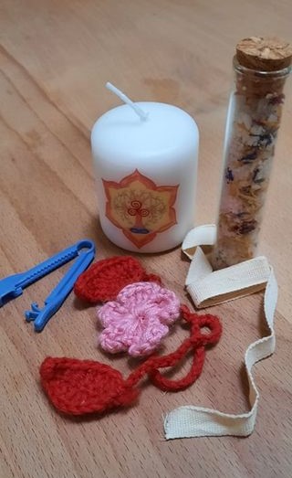 Anja Lehnertz is presenting different ways of dealing with the umbilical cord in this picture: a plastic umbilical clamp, a candle to burn it through, two different kinds of cord ties and a mixture of salt and herbs, which is used during a lotus birth.