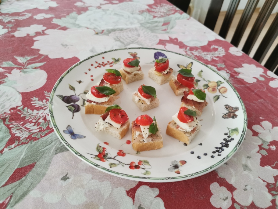 Weissbrot geviertelt Räucherschinken auf einer Butter und Frischkäse Grundlage mit Cherrytomate Pfeffer Briese Salz Öl und Basilikumblättchen