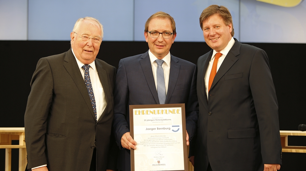 Firmengründer Hans Jaeger (l.)und sein Sohn, der heutige Gesellschafter Johann Jaeger erhalten vom Landrat Markus Bauer (Mitte) die Ehrenurkunde.