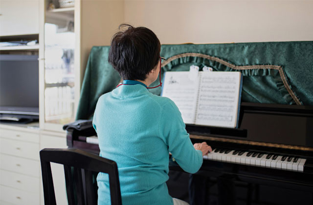 自宅でピアノを弾く女性
