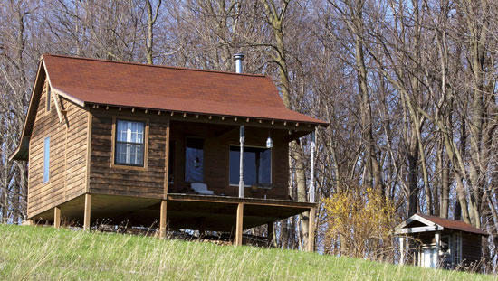 ギボン家のオフグリッドの手製のゲスト小屋と野外便所は、数あるDIY作業の内の2つ。