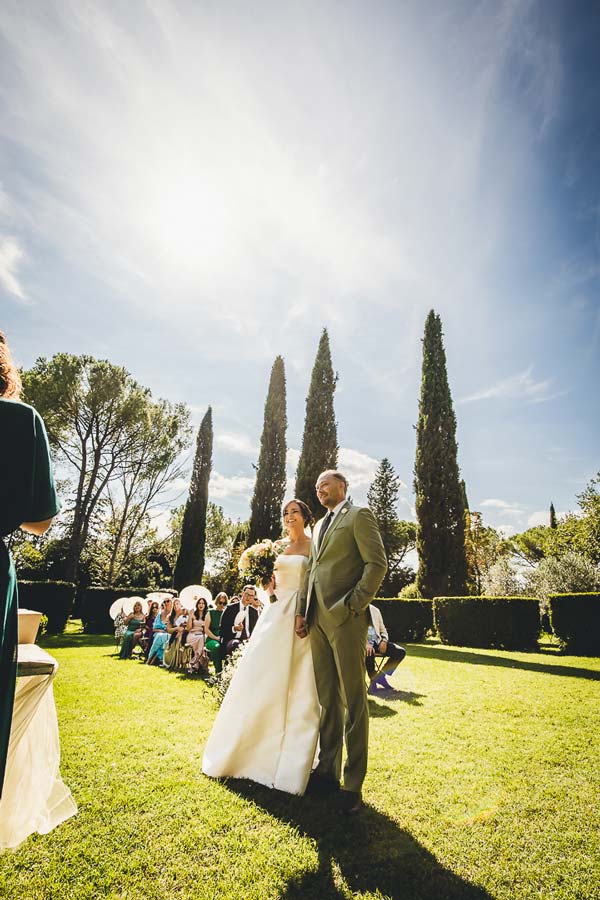Intimate double wedding in Italy with guests gathered in a historic castle courtyard