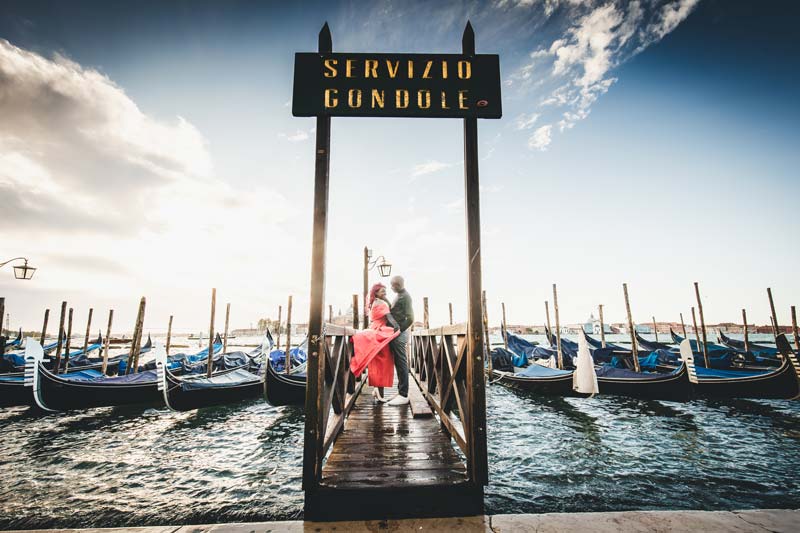An elegant couple posing at sunset in front of the Basilica di San Marco for their anniversary photoshoot