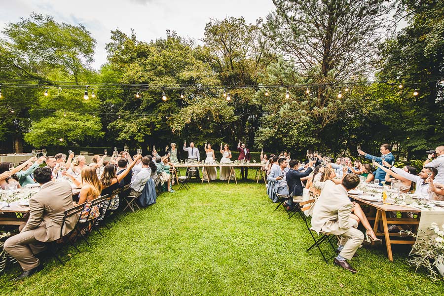 Double wedding celebration in Tuscany with dancing guests under the night sky