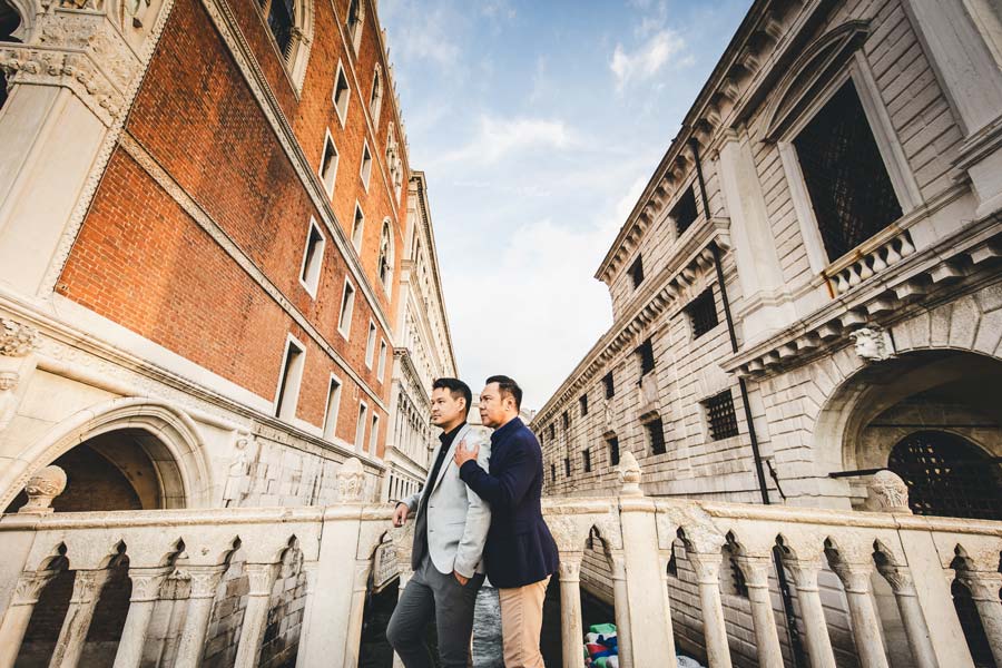 Stylish LGBTQ+ couple posing on a Bridge with morning light