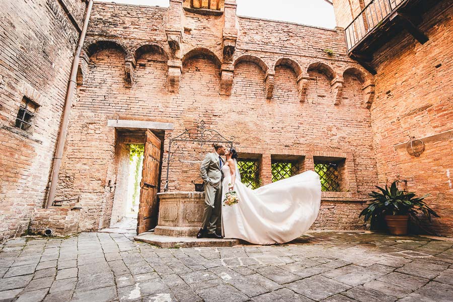 Bride and groom detail shot with wedding rings and bouquet in Tuscan style setting
