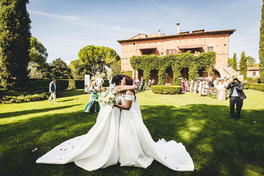 Romantic portrait of newlyweds walking through the Tuscan countryside near the castle