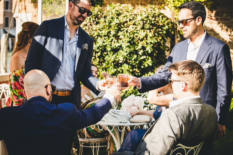 The newlyweds standing in a quiet, sun-drenched Venetian alleyway.
