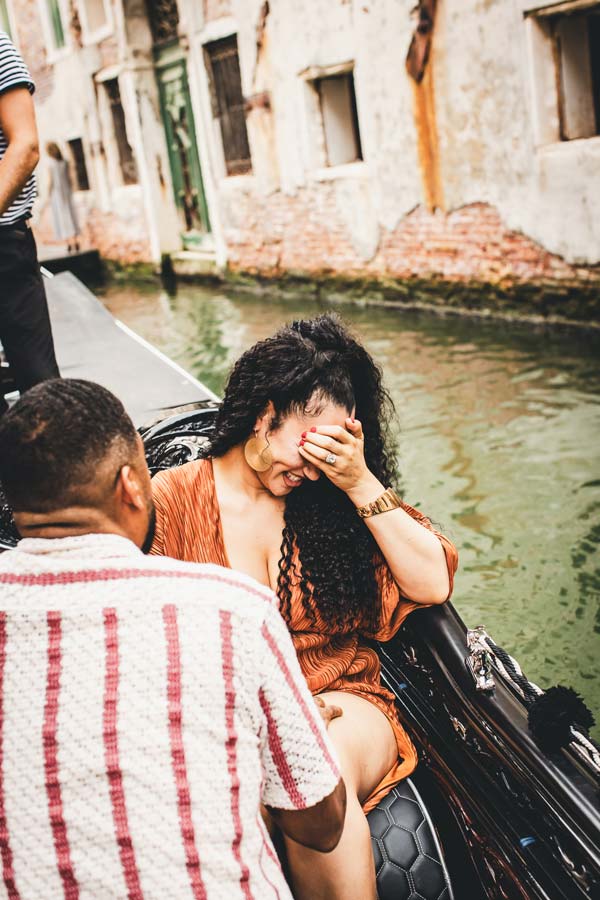 Emotional reaction of a woman during a surprise proposal in Venice