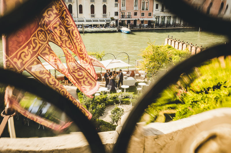 The couple enjoying a quiet moment on a private balcony overlooking the hotel's garden.
