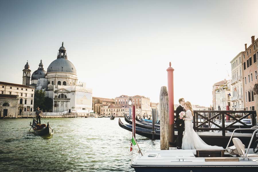 Sunset over Venice behind the couple in wedding attire