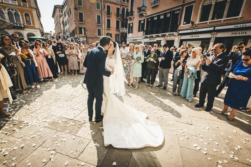 Romantic portrait of the couple standing on the Hotel Monaco balcony overlooking the Grand Canal.