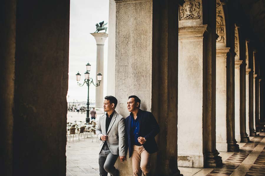 Gay couple with soft pastel skies over Venice in the background
