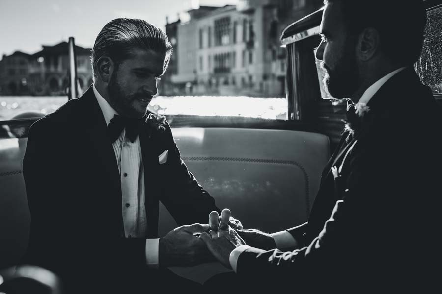 Close-up of two grooms holding hands during their Venice elopement photoshoot.