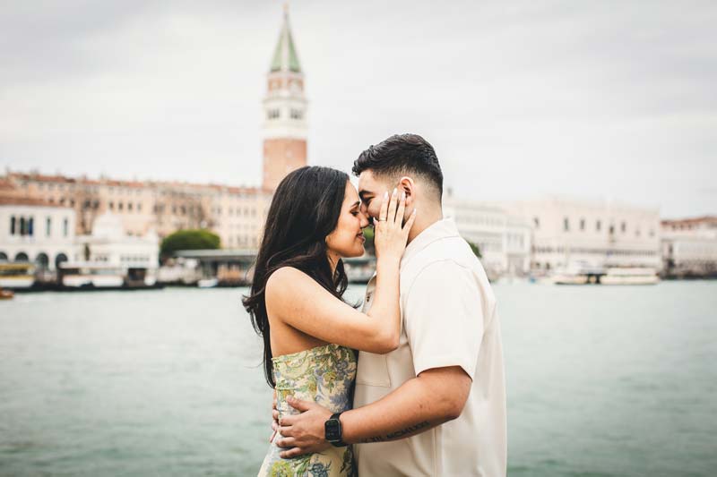 Dramatic sunrise photo of a couple on a quiet bridge in Venice.