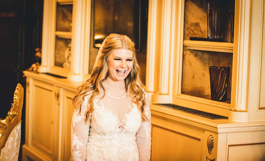 Bride touching the ornate mirror in a vintage-style room