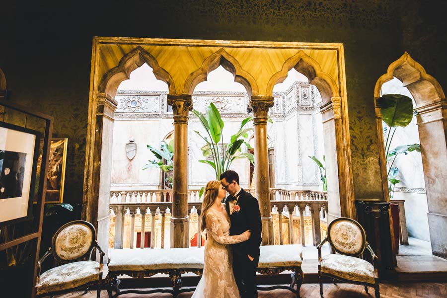 Romantic portrait of newlyweds under the Gothic arches of the hotel