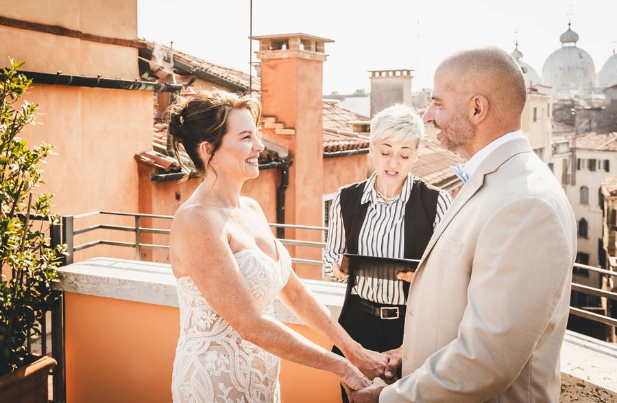 Bride smiling with Venice rooftops behind her at golden hour