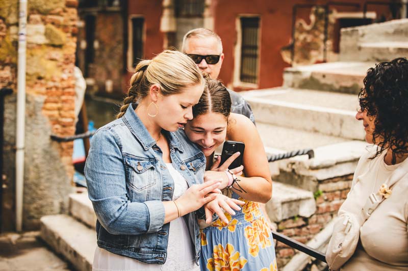 Couple smiling while walking through narrow calli in Cannaregio