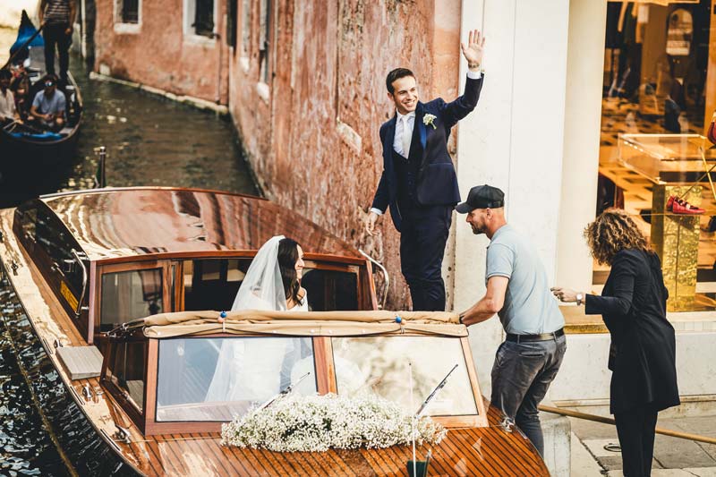 Venice wedding reportage couple walking hand-in-hand through a quiet calle.