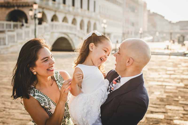 Family sharing a funny moment in a picturesque Venetian square, captured candidly to show real vacation joy during their Venice photoshoot.