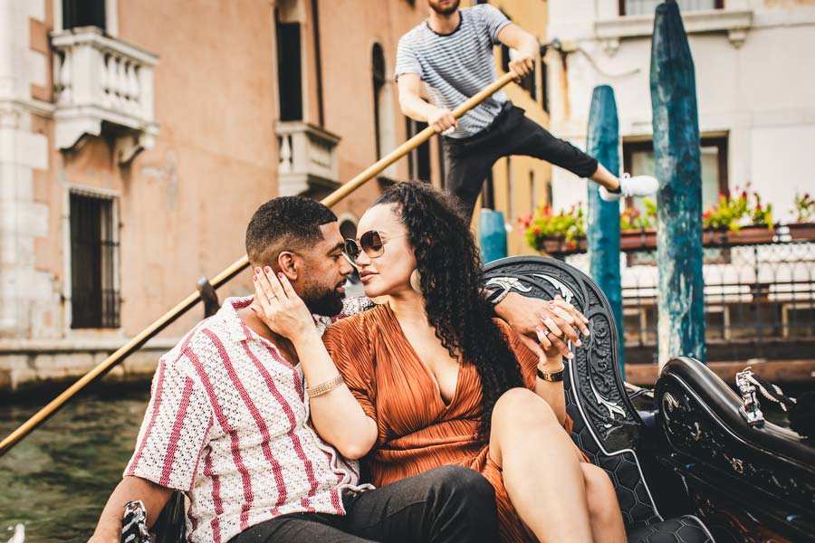 Couple sharing a kiss after a surprise proposal on the Grand Canal